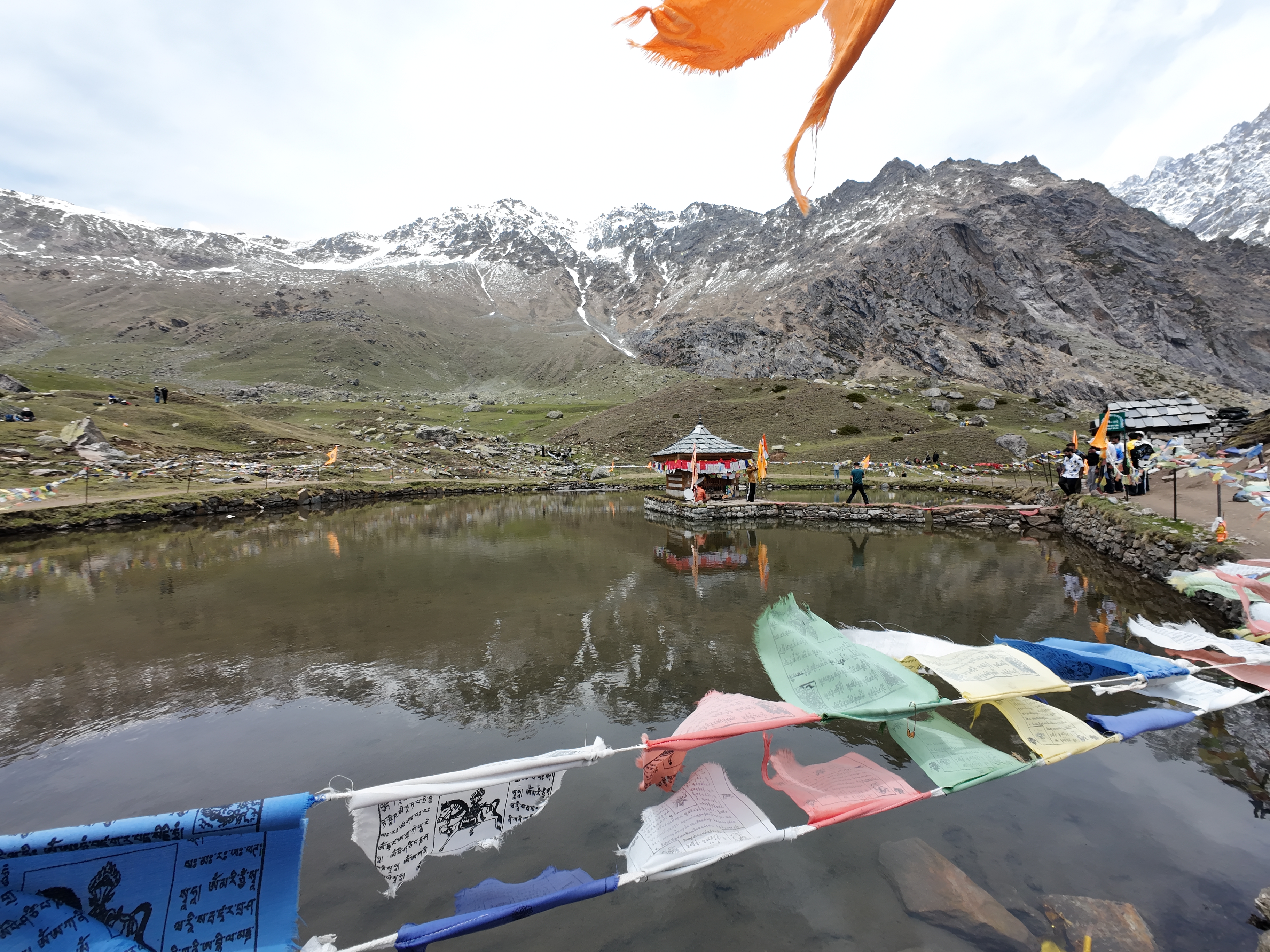 Yulla Kanda Krishna temple on the sacred lake with prayer flags and Kinner Kailash backdrop