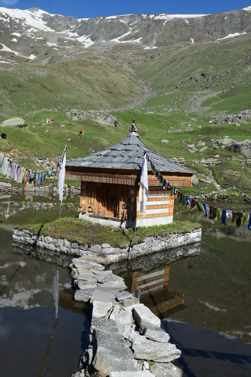 Yulla Kanda Krishna temple on the sacred lake with stone path and prayer flags