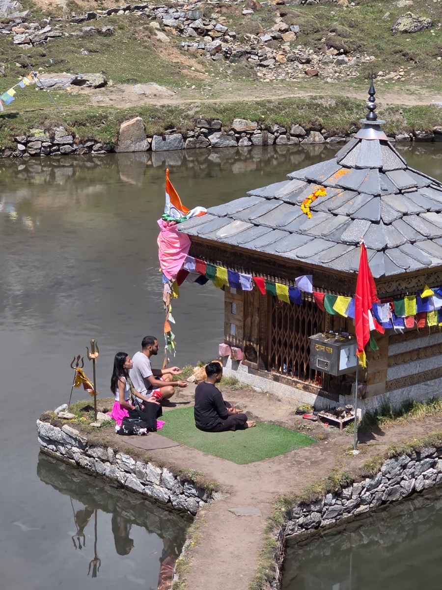 Devotees performing puja at Yulla Kanda Krishna temple on the sacred lake